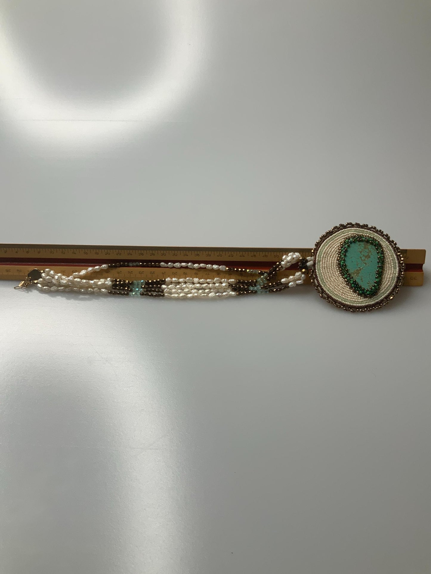 T.G. 2007 signed Turqoise beaded pendant on leather with three stands of pearls and other material beads with a open box 14k gold clasp.