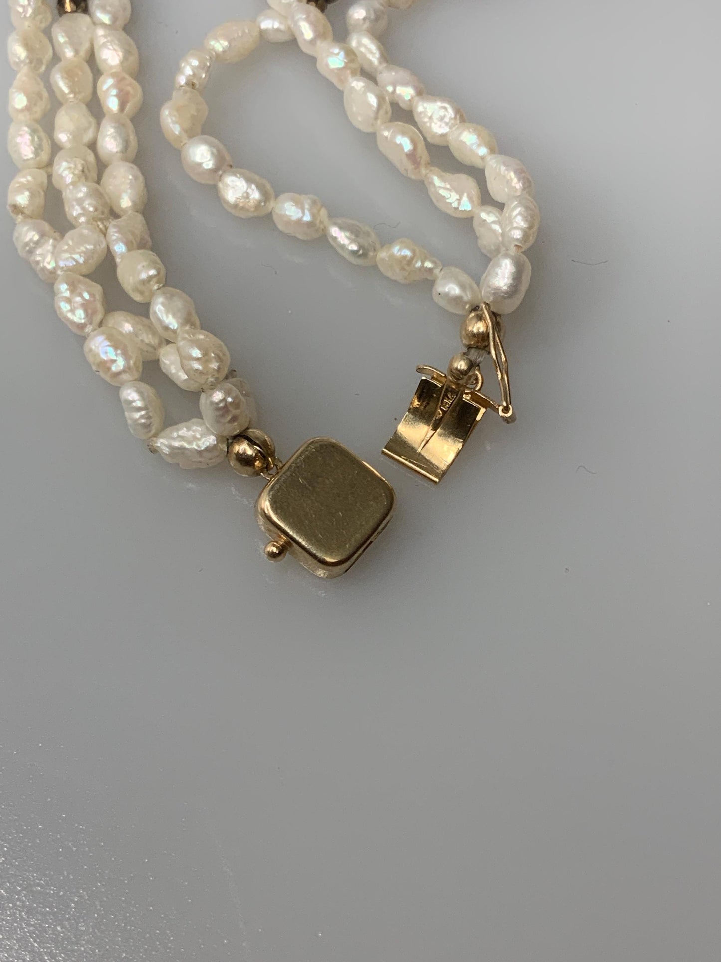 T.G. 2007 signed Turqoise beaded pendant on leather with three stands of pearls and other material beads with a open box 14k gold clasp.