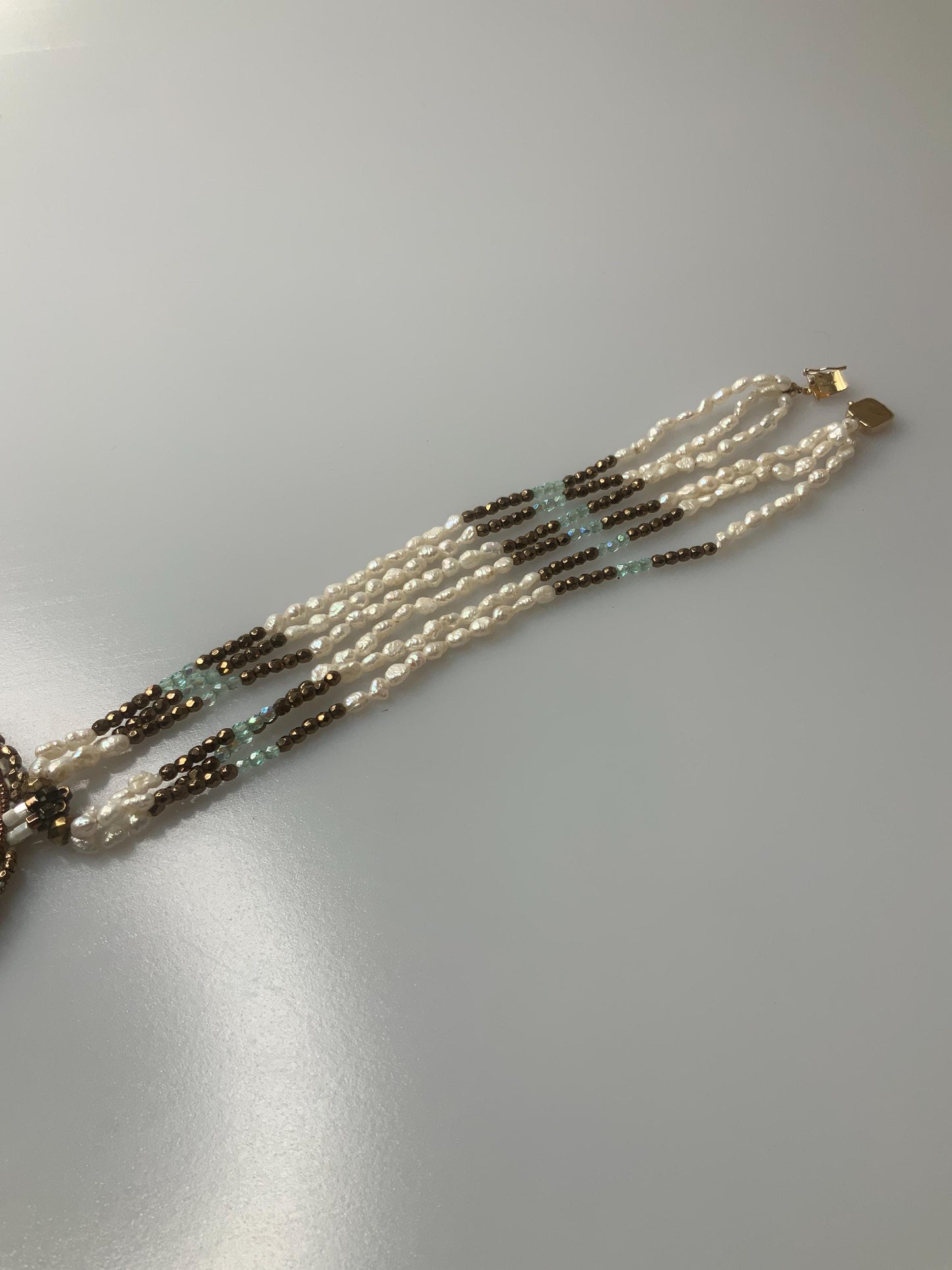 T.G. 2007 signed Turqoise beaded pendant on leather with three stands of pearls and other material beads with a open box 14k gold clasp.